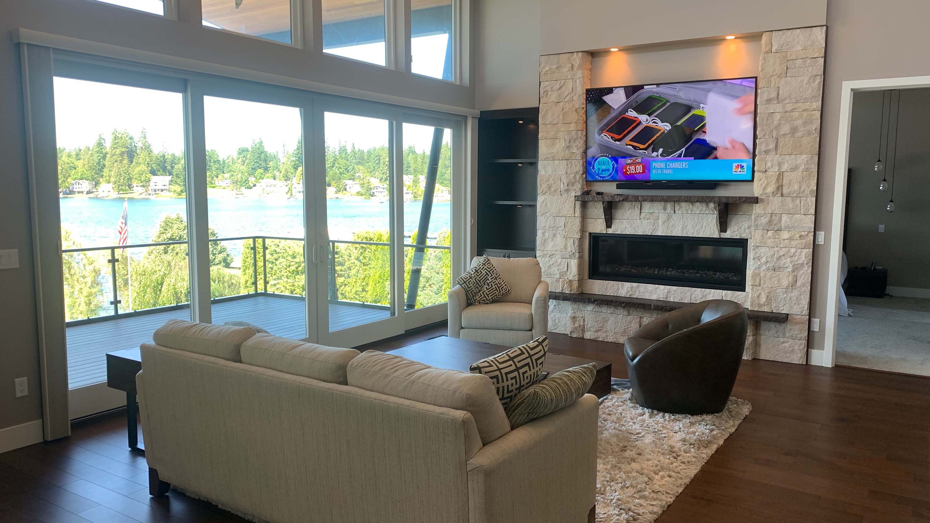 couches in living room, large windows, television