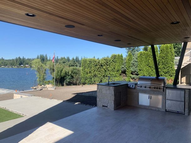 Back patio with outdoor kitchen, construction on yardwork, lake view
