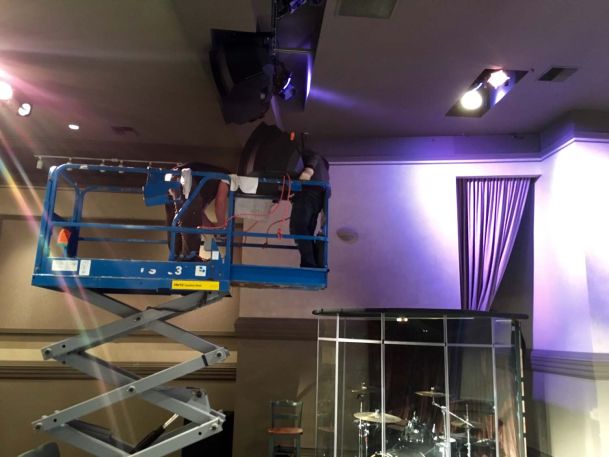 Men installing technology in ceiling purple lighting