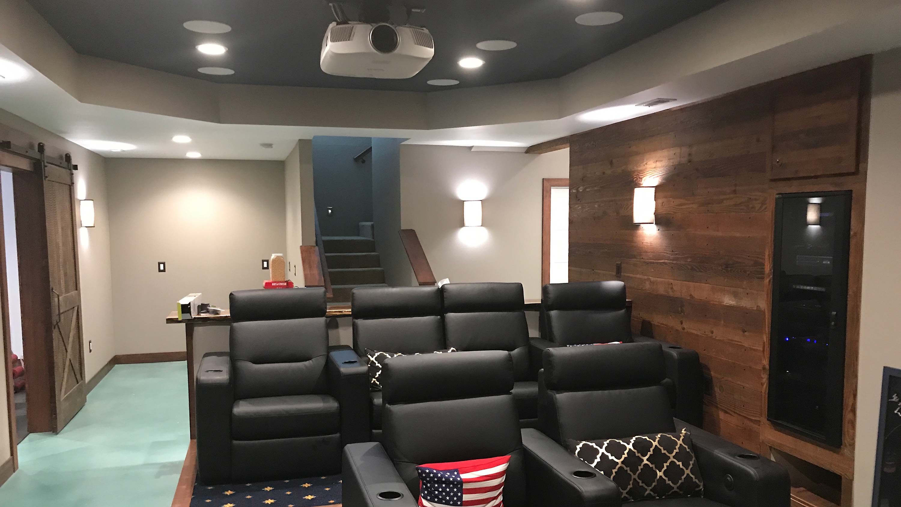 home theater, wood paneling, black armchairs, video projection